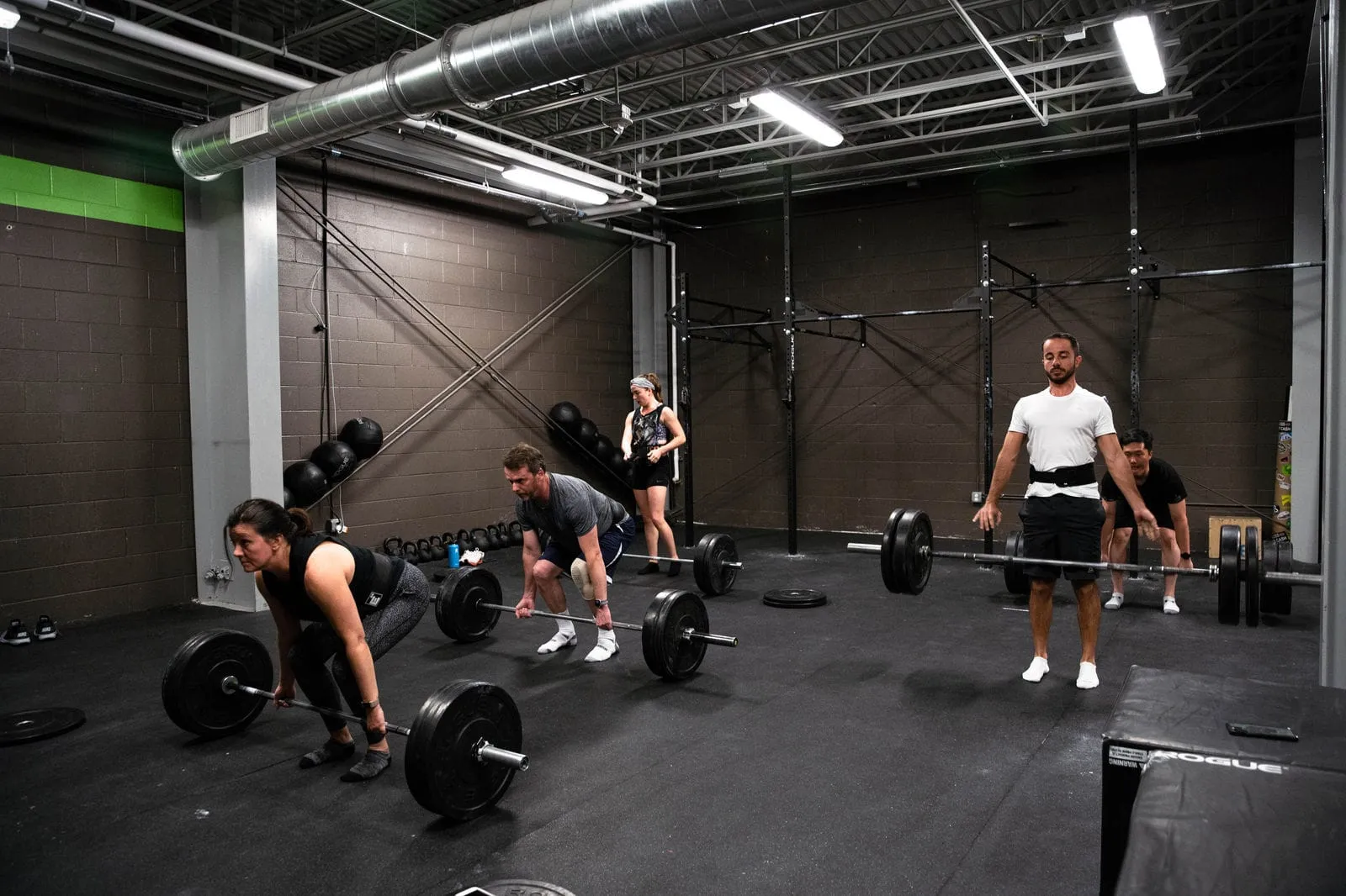 A CrossFit class lifting barbells