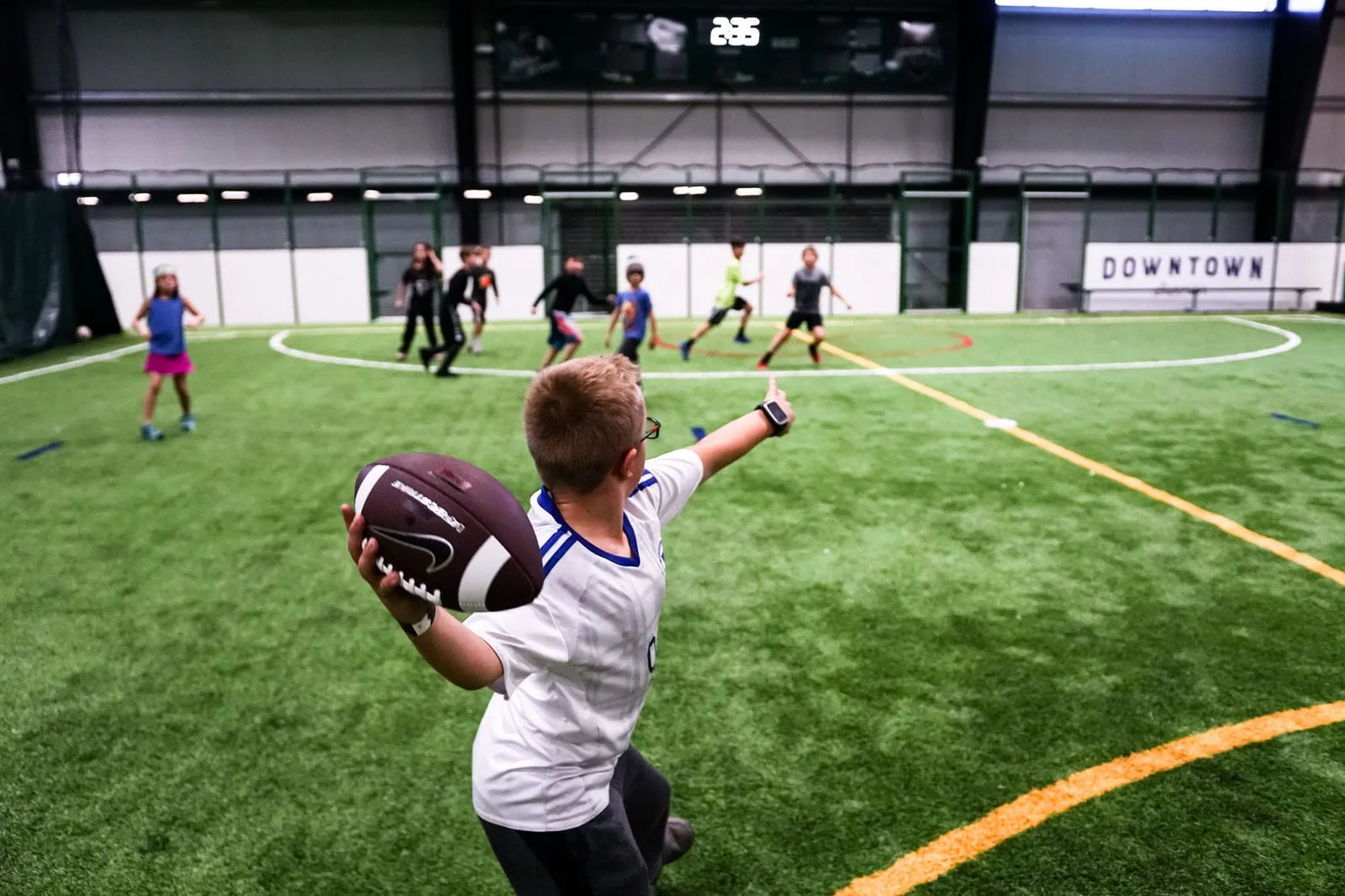 Kids playing flag football on the turf